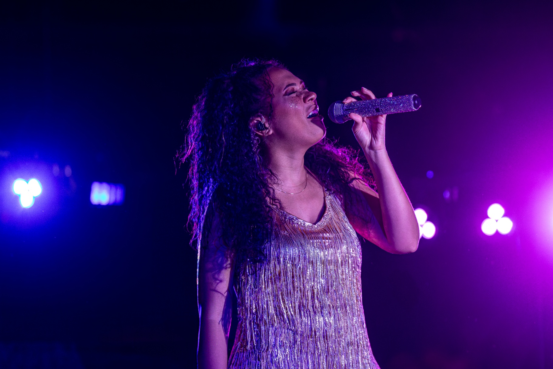 Manix Rho vocalist performing under purple stage lights